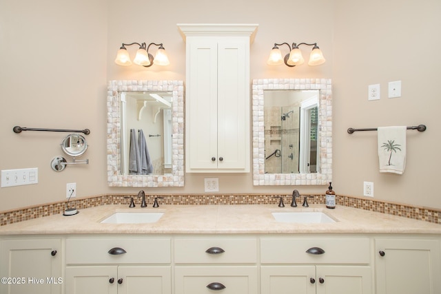 bathroom with a sink, a shower stall, and double vanity