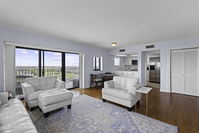 322 Causeway Dr Ste 1001, Wrightsville Beach, NC 28480 - living area featuring visible vents, baseboards, crown molding, and dark wood-style floors