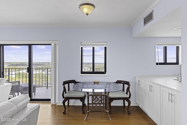 322 Causeway Dr Ste 1001, Wrightsville Beach, NC 28480 - dining area featuring crown molding, visible vents, plenty of natural light, and wood finished floors