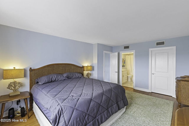 322 Causeway Dr Ste 1001, Wrightsville Beach, NC 28480 - bedroom featuring ensuite bath, visible vents, baseboards, and wood finished floors