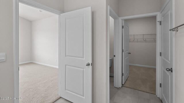 hallway with light carpet and baseboards