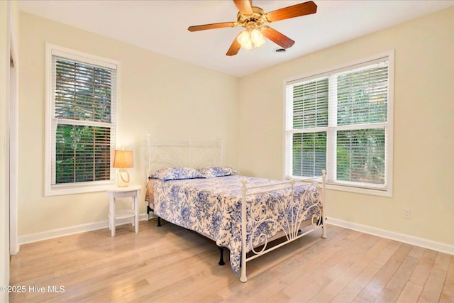 154 Windsor Cir SW, Ocean Isle Beach, NC 28469 - bedroom with wood finished floors, multiple windows, and baseboards