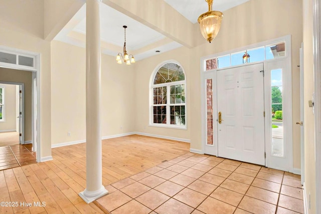 154 Windsor Cir SW, Ocean Isle Beach, NC 28469 - entryway with light wood-style floors, a chandelier, a raised ceiling, and baseboards