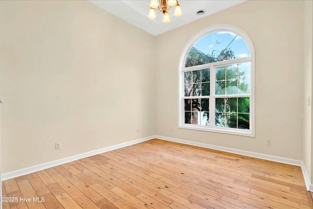 154 Windsor Cir SW, Ocean Isle Beach, NC 28469 - unfurnished room featuring a chandelier, baseboards, and light wood finished floors