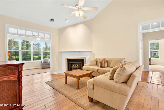 154 Windsor Cir SW, Ocean Isle Beach, NC 28469 - living area featuring vaulted ceiling, light wood-style flooring, a fireplace with flush hearth, ceiling fan, and baseboards