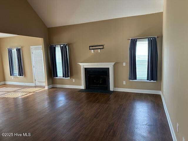 107 Pinyon Ln, Ayden, NC 28513 - unfurnished living room featuring baseboards, vaulted ceiling, wood finished floors, and a fireplace with flush hearth