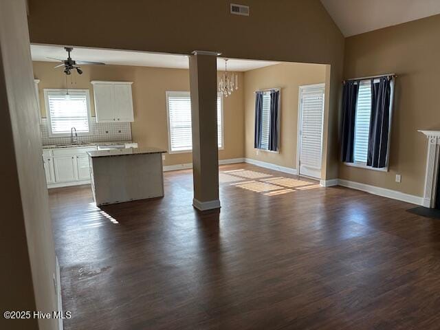 107 Pinyon Ln, Ayden, NC 28513 - unfurnished living room featuring ceiling fan with notable chandelier, dark wood-type flooring, visible vents, a sink, and plenty of natural light