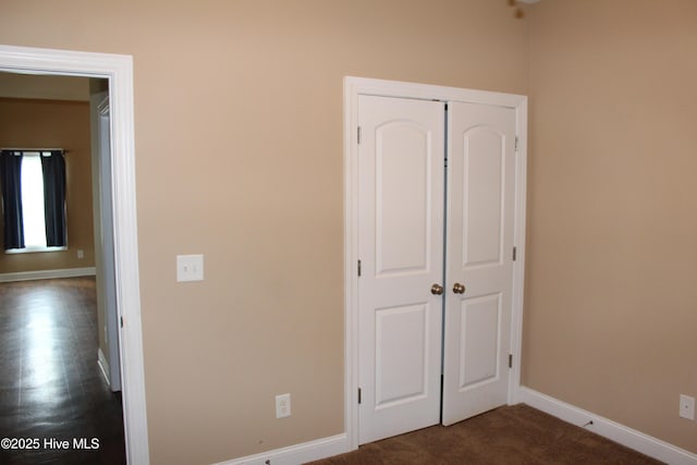 107 Pinyon Ln, Ayden, NC 28513 - unfurnished bedroom with a closet, baseboards, and dark colored carpet
