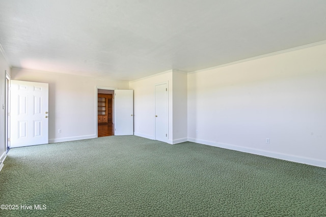 empty room with ornamental molding, baseboards, and carpet flooring