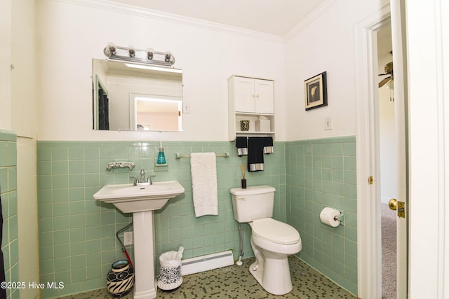 half bathroom featuring ornamental molding, tile walls, toilet, a wainscoted wall, and a baseboard heating unit