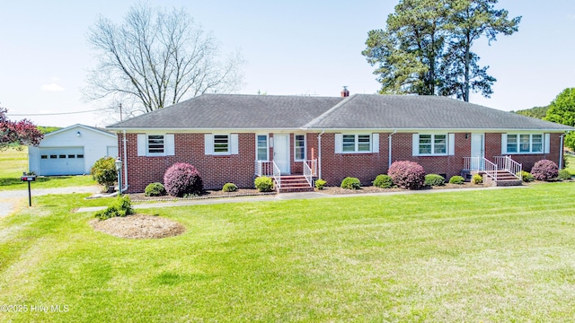 single story home with a garage, a front yard, an outdoor structure, and brick siding