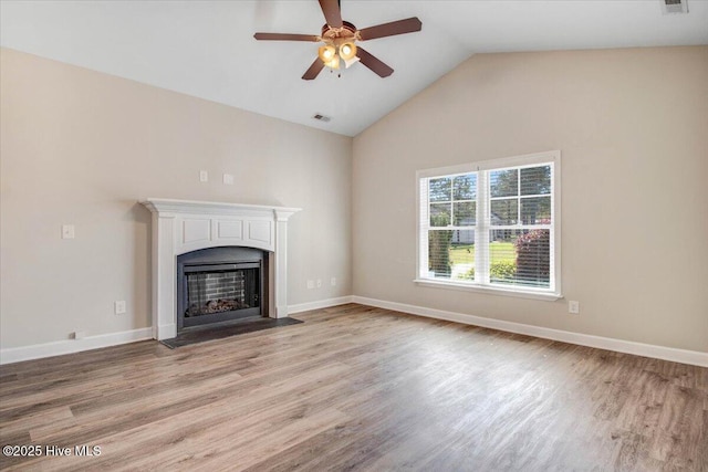 unfurnished living room with vaulted ceiling, a ceiling fan, a fireplace with flush hearth, visible vents, and light wood finished floors