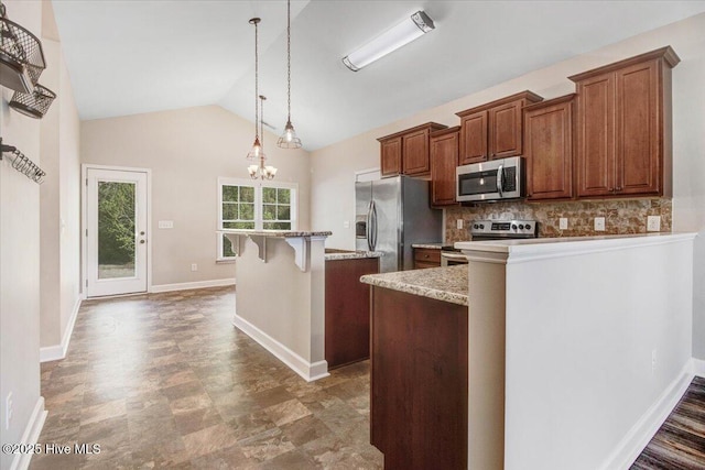 kitchen with a breakfast bar, vaulted ceiling, a kitchen island, brown cabinetry, and stainless steel appliances