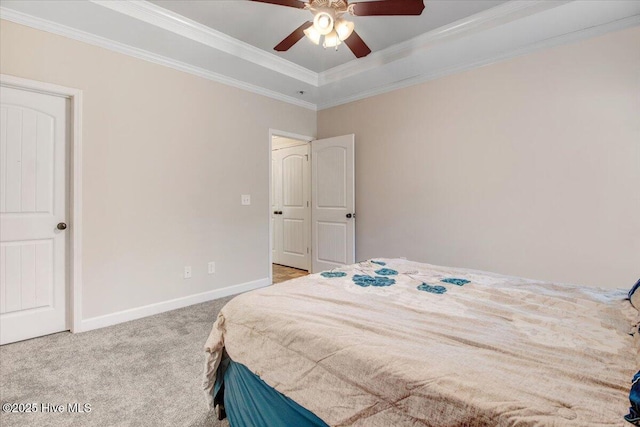 bedroom with crown molding, baseboards, a raised ceiling, and carpet