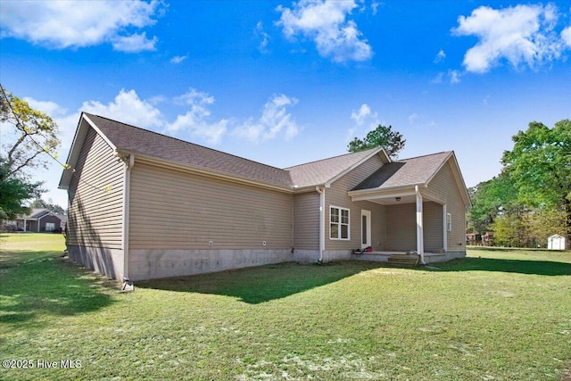 rear view of house featuring a yard