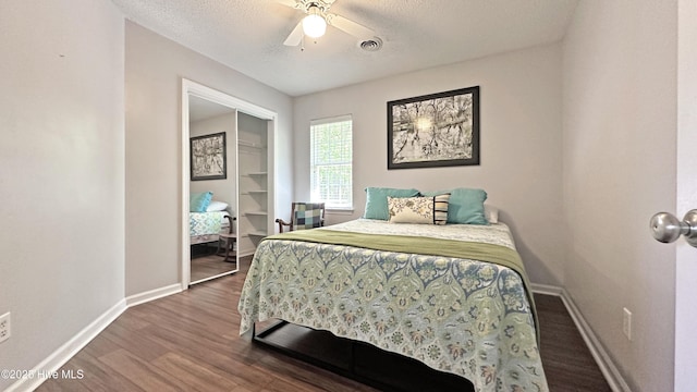 bedroom featuring visible vents, baseboards, a textured ceiling, and wood finished floors