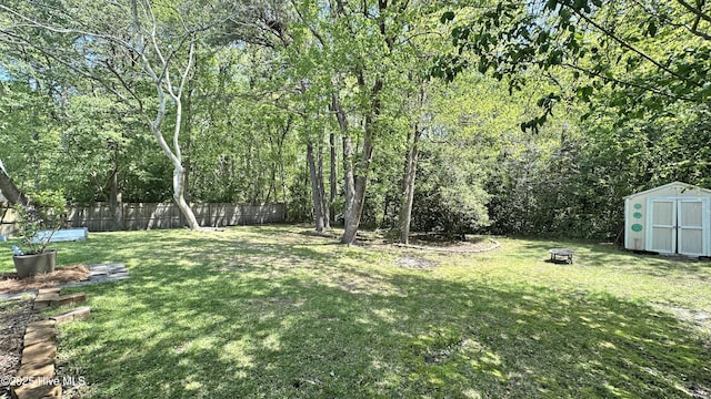 view of yard with a shed, an outdoor structure, and fence