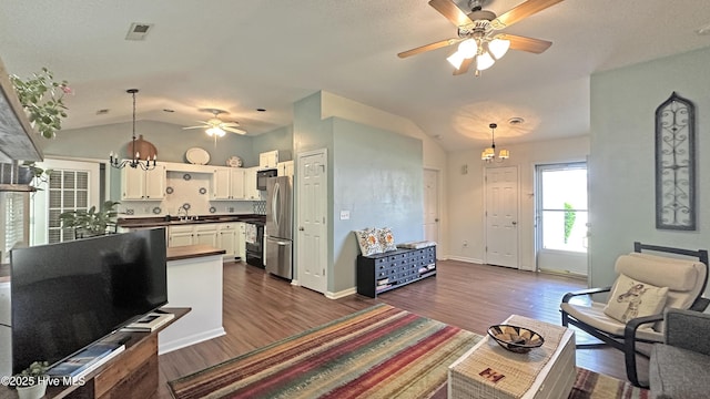 living area featuring dark wood-type flooring, baseboards, lofted ceiling, and ceiling fan with notable chandelier