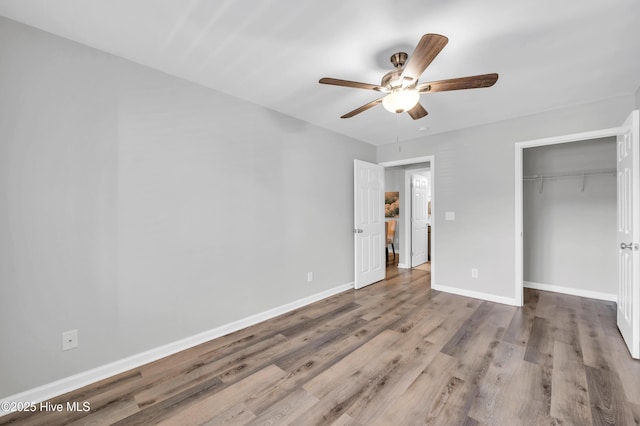 unfurnished bedroom with wood finished floors, a closet, baseboards, and ceiling fan