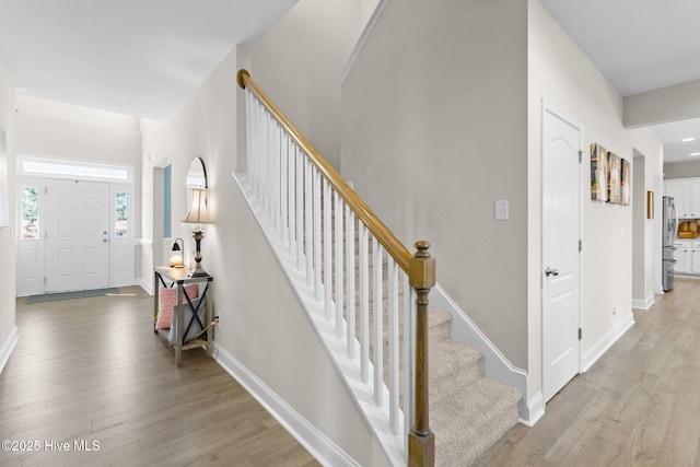 stairs featuring wood finished floors and baseboards