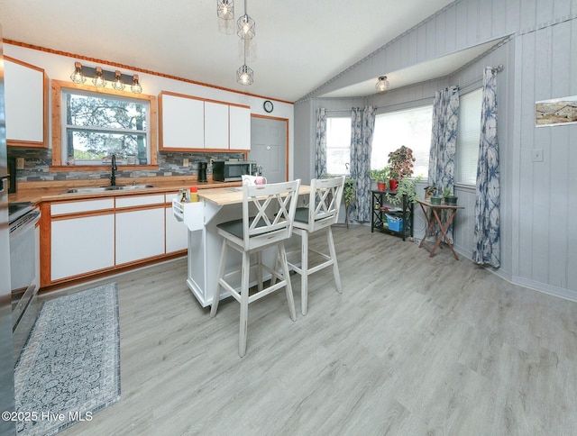 105 Blue Heron Rd, Shiloh, NC 27974 - kitchen featuring a sink, stainless steel microwave, vaulted ceiling, backsplash, and white cabinets
