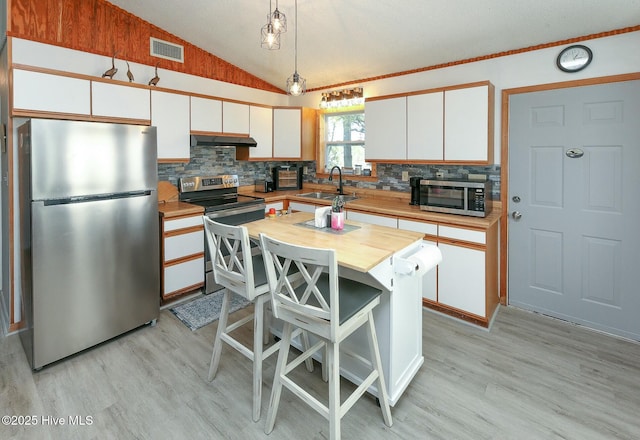 105 Blue Heron Rd, Shiloh, NC 27974 - kitchen featuring appliances with stainless steel finishes, a sink, white cabinets, light wood-style floors, and vaulted ceiling