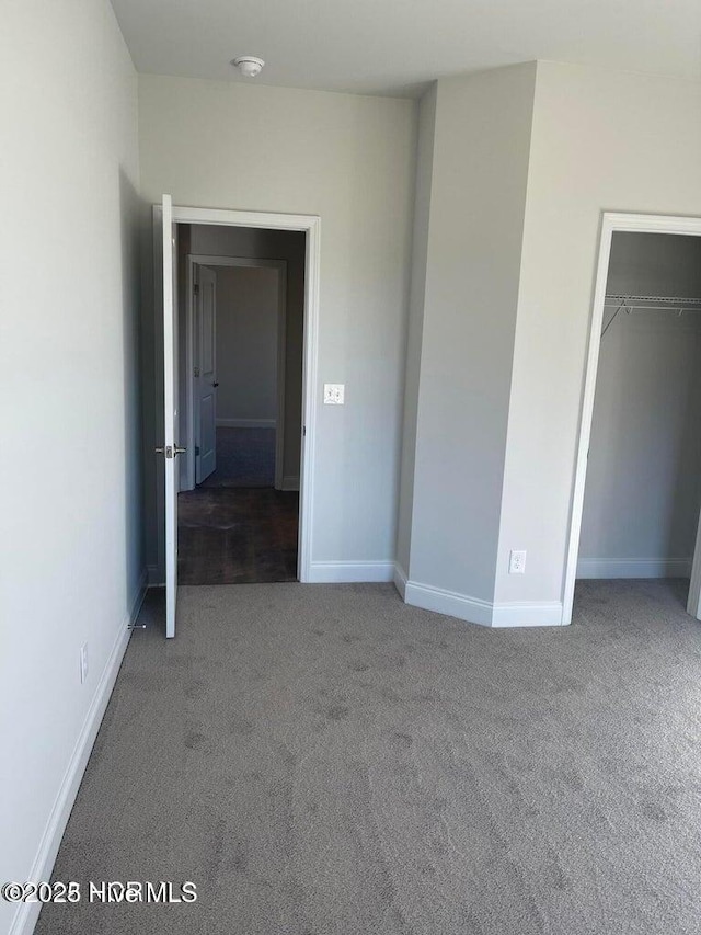 unfurnished bedroom featuring a closet, carpet flooring, and baseboards