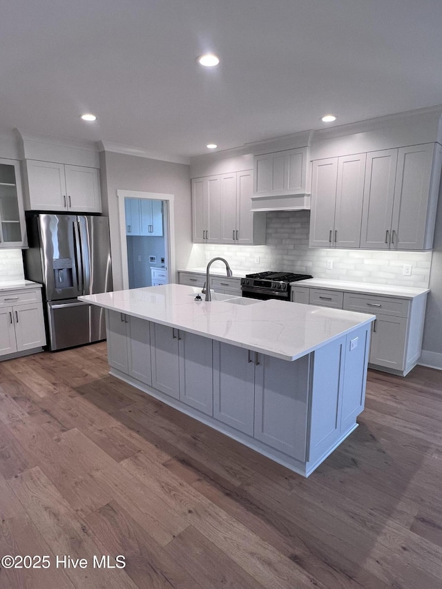 3216 Whichards Beach Rd, Chocowinity, NC 27817 - kitchen featuring appliances with stainless steel finishes, a sink, dark wood-type flooring, backsplash, and a kitchen island with sink