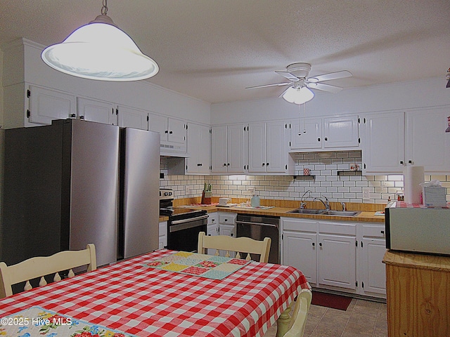 kitchen with freestanding refrigerator, under cabinet range hood, electric stove, dishwasher, and a sink