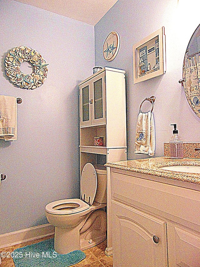 bathroom featuring tile patterned flooring, toilet, and vanity