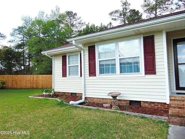 view of property exterior with a yard, fence, and crawl space