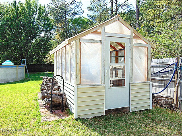 view of greenhouse featuring a yard and a fenced backyard
