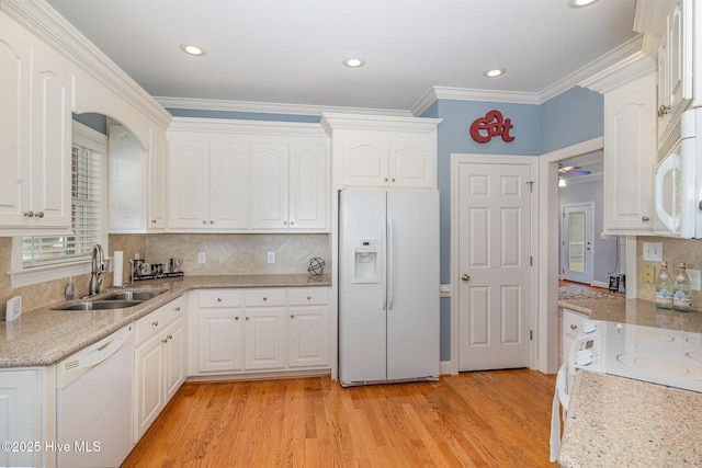 kitchen featuring white cabinetry, ornamental molding, a sink, and white appliances