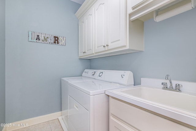laundry room with baseboards, washer and dryer, a sink, cabinet space, and tile patterned floors
