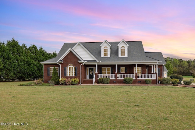 view of front facade with a porch, a front lawn, and brick siding