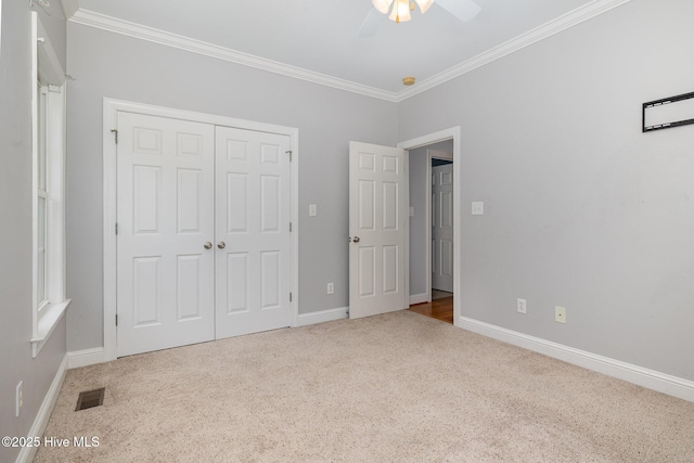 unfurnished bedroom with crown molding, visible vents, baseboards, and carpet flooring