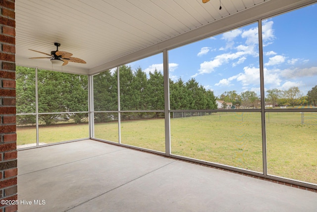 unfurnished sunroom featuring a ceiling fan