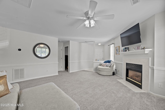 living room featuring carpet floors, a ceiling fan, visible vents, and a premium fireplace