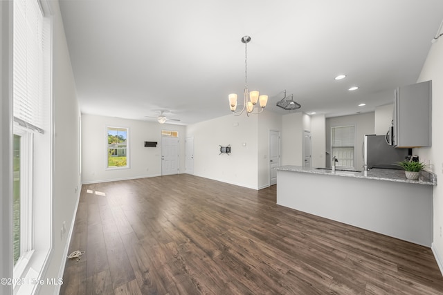 kitchen featuring pendant lighting, ceiling fan with notable chandelier, a peninsula, recessed lighting, and dark wood-style floors