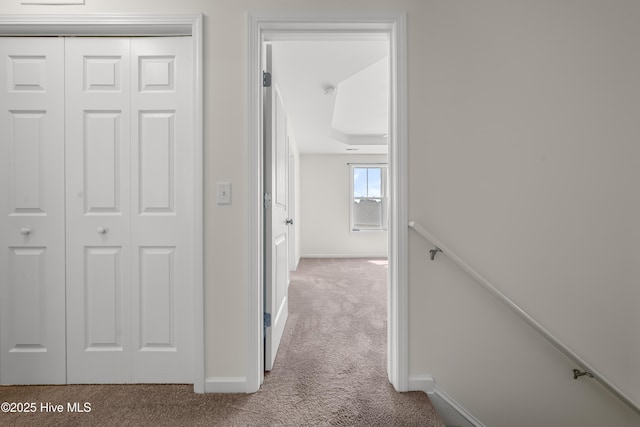 corridor with baseboards and carpet flooring