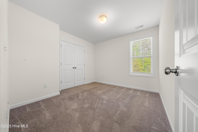 unfurnished bedroom with visible vents, baseboards, and carpet flooring