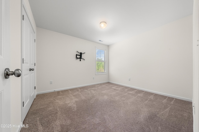 spare room with baseboards, visible vents, and carpet floors
