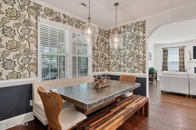 104 Old Club House Ln, Southern Pines, NC 28387 - dining area with visible vents, crown molding, wood finished floors, wallpapered walls, and arched walkways