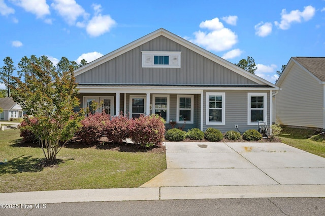 view of front of home featuring a porch, a front lawn, and board and batten siding