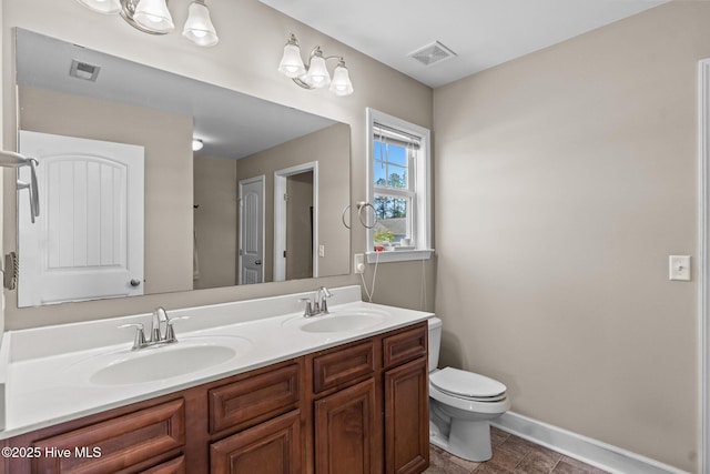 bathroom with a sink, toilet, and visible vents