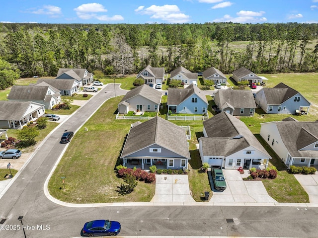 drone / aerial view featuring a view of trees and a residential view