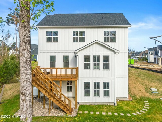 rear view of property with roof with shingles, stairs, a deck, and a yard