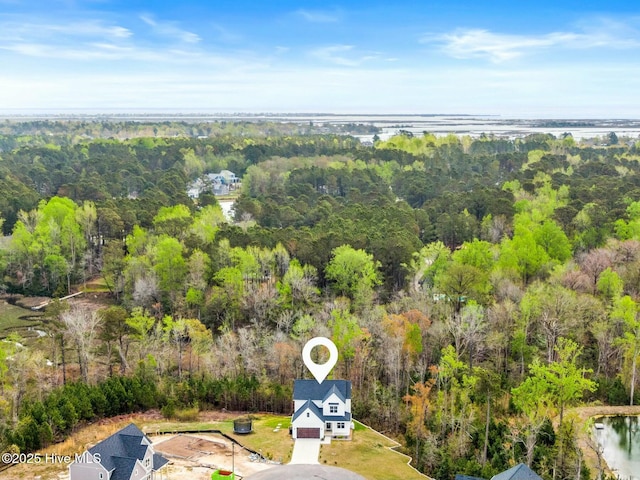 birds eye view of property featuring a forest view and a water view