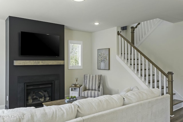 living area with recessed lighting, stairs, baseboards, and wood finished floors