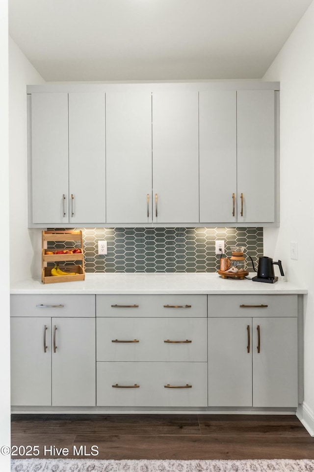 bar featuring dark wood-type flooring and decorative backsplash
